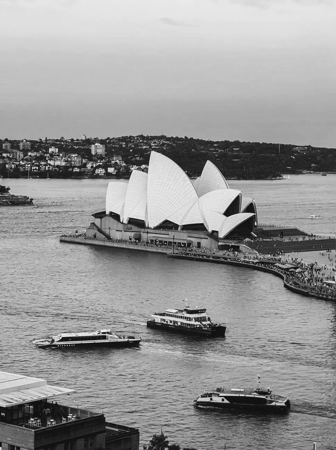 Sydney Opera House with boats in harbor.